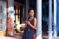 Smiling woman standing outside with earphones and mobile phone Royalty Free Stock Photo