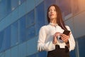 Smiling woman stands near office and chats with friend