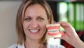 Smiling woman stomatologist showing perfect tooth model