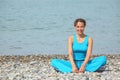 Smiling woman is stretching on a coast of sea Royalty Free Stock Photo