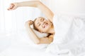 Smiling woman stretching hands in bed after waking up, entering a day happy and relaxed. Sweet dreams, sunny morning Royalty Free Stock Photo