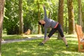 Smiling woman stretching in park on sunny day Royalty Free Stock Photo