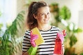 Smiling woman in striped shirt in sunny day housecleaning