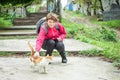 Smiling woman stroking a purring cat on the street. Homeless animal Royalty Free Stock Photo