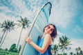 Smiling woman with surfboard posing on tropical beach