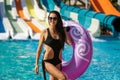 Smiling woman with swim ring near pool and slides Royalty Free Stock Photo