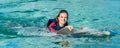 Smiling woman swimming with dolphin in blue water Royalty Free Stock Photo