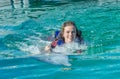 Smiling woman swimming with dolphin in blue water Royalty Free Stock Photo
