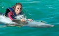 Smiling woman swimming with dolphin in blue water Royalty Free Stock Photo