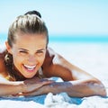 smiling woman in swimsuit laying on beach Royalty Free Stock Photo