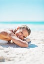 Smiling woman in swimsuit laying on sandy beach Royalty Free Stock Photo