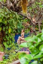 Smiling woman in swimsuit relax in swimming pool among tropical trees in luxury resort. Female traveler on spa lounge Royalty Free Stock Photo