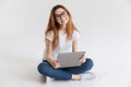 Smiling woman in t-shirt and eyeglasses sitting on the floor Royalty Free Stock Photo