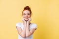 Smiling woman in t-shirt reclines on hands and looking away