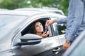 Smiling woman takes car key. A man`s hand gives keys from car with buttons to open or close the car door lock. Royalty Free Stock Photo