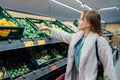 Smiling woman taking fresh organic limes in the supermarket store during selecting fresh products. Grocery Shopping Royalty Free Stock Photo