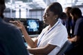 Smiling woman talking with colleague in server room, creating AI systems