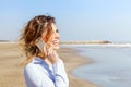 Smiling woman talking on the mobile phone at the seaside