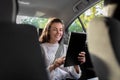 smiling woman in taxi car using tablet pc computer
