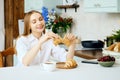 Smiling woman tears apart a fresh croissant