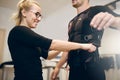 Smiling woman tightening belt on man ems suit Royalty Free Stock Photo