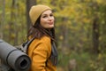 Smiling woman tourist enjoys hiking in autumn forest Royalty Free Stock Photo