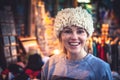 Smiling woman tourist trying on traditional Balkan hat on local souvenir market during her travel holidays