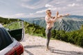 smiling woman travel by car in mountains and taking photos on smartphone Royalty Free Stock Photo