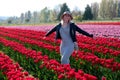 Smiling woman in tulip fields.