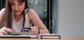 Smiling woman use mobile phone for shopping online with credit card Royalty Free Stock Photo