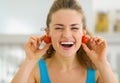 Smiling woman using cherry tomato as earrings Royalty Free Stock Photo