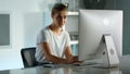 Smiling woman using desktop computer at home office. Corporate worker lifestyle Royalty Free Stock Photo