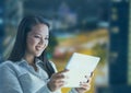 Smiling woman using a digital tablet with buildings in background Royalty Free Stock Photo