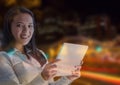 Smiling woman using a digital tablet in lights Royalty Free Stock Photo