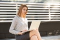 Smiling woman using her laptop outside Royalty Free Stock Photo