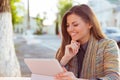 Smiling woman using her tablet outside on a city street background Royalty Free Stock Photo