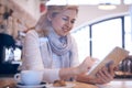 Smiling woman using tablet sitting from behind window Royalty Free Stock Photo