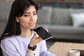 Smiling woman using voice search assistant on smartphone Royalty Free Stock Photo