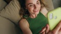 Smiling woman videocalling telephone laying sofa closeup. Happy girl talking