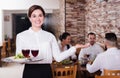 Smiling woman waiter carrying order for visitors Royalty Free Stock Photo