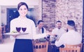 Smiling woman waitress carrying order for visitors Royalty Free Stock Photo