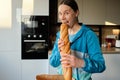 Smiling woman wants to bite a baguette