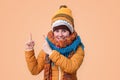 Smiling woman in warm winter clothes scarf and hat pointing up Royalty Free Stock Photo