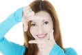 Smiling woman wearing blue blouse is showing frame by hands. Royalty Free Stock Photo