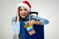 Smiling woman wearing christmas santa hat holding passport, tick Royalty Free Stock Photo