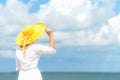 Smiling woman wearing fashion white dress summer walking on the sandy ocean beach, beautiful blue sky background. Happy woman enjo Royalty Free Stock Photo