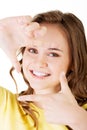 Smiling woman wearing red blouse is showing frame by hands. Royalty Free Stock Photo