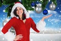 Smiling woman wearing santa costume pretending to hold digitally generated christmas baubles Royalty Free Stock Photo