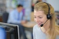 smiling woman wearing telephone headset using computer Royalty Free Stock Photo