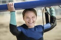 Middle aged woman in wetsuit holding surfboard